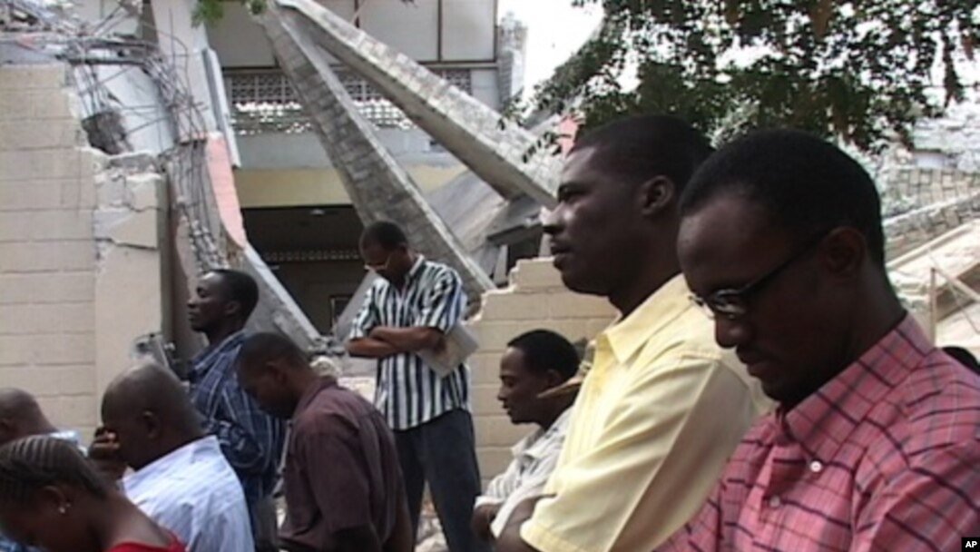Catholics in Haiti attend mass outside after their church was heavily damaged in the recent earthquake.