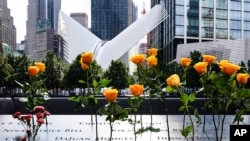 Se colocan flores con los nombres inscritos de los fallecidos en el Museo y Memorial Nacional del 11 de septiembre, el viernes 11 de septiembre de 2020, en Nueva York. 