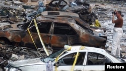 A forensic inspector takes pictures at the site of a car bomb that occurred on Thursday in Beirut's southern suburbs, August 16, 2013. 