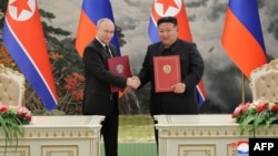 Ảnh chụp ngày 19/6/2024 của Thông tấn xã Trung ương Triều Tiên (KCNA) cho thấy lãnh đạo Triều Tiên Kim Jong Un (phải) và Tổng thống Nga Vladimir Putin (trái) bắt tay nhau tại lễ ký kết sau cuộc hội đàm song phương ở Bình Nhưỡng, Triều Tiên.