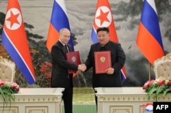 មេដឹកនាំកូរ៉េខាងជើងលោក Kimg Jong Un និង​ប្រធានាធិបតី​រុស្ស៊ី​លោក​ Vladimir Putin ចាប់ដៃគ្នាក្រោយចុះហត្ថលេខាលើ​កិច្ចព្រមព្រៀង​យុទ្ធសាស្ត្រ​រវាងប្រទេសទាំងពីរ​នៅទីក្រុងព្យុងយ៉ាង ប្រទេសកូរ៉េខាងជើង កាលពីថ្ងៃទី១៩ ខែមិថុនា ឆ្នាំ២០២៤។ (KCNA VIA KNS / AFP)