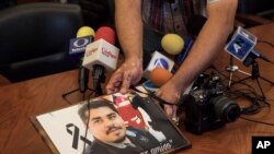 A member of the media displays an image of slain Mexican journalist Edgar Daniel Esqueda Castro, in protest, before the start of a press conference in San Luis Potosi, Mexico, Oct. 6, 2017. The body of Esqueda Castro, a freelance photographer, was found one day after armed men wearing uniforms abducted him from his home. 