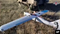 In this photo taken from video distributed by Russian Defense Ministry Press Service on Jan. 26, 2025, a Russian serviceman prepares a "Orlan-10" drone in an undisclosed location in Ukraine. 