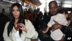 Kim Kardashian dan Kanye West serta anak perempuannya North terlihat di Bandara LAX di Los Angeles, California, 8 April 2015.