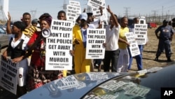 A group of protesters follow retired judge Ian Farlam and his team as they inspect the area where the bodies of mine workers were found after the shootings at Lonmin's platinum mine in Marikana near Rustenburg, South Africa, Oct. 1, 2012. 