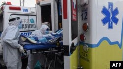 Tenaga kesehatan membawa pasien Covid-19 ke rumah sakit umum Medellin, Kolombia, dengan ambulans, 3 Agustus 2020. (Foto: JOAQUIN SARMIENTO / AFP)