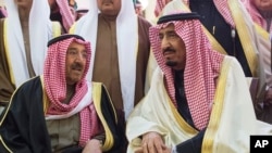 In this photo provided by Saudi Press Agency, newly enthroned King Salman, right, talks with Kuwait's emir, Sheikh Sabah Al-Ahmad Al-Jaber Al-Sabah, during King Abdullah's funeral in Riyadh, Jan. 23, 2015.