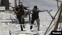 Free Syrian Army fighters run to take cover away from the exchange fire while fighting with regime forces in the Seif El Dawla neighbourhood of Syria's south west city of Aleppo, August 24, 2012. 