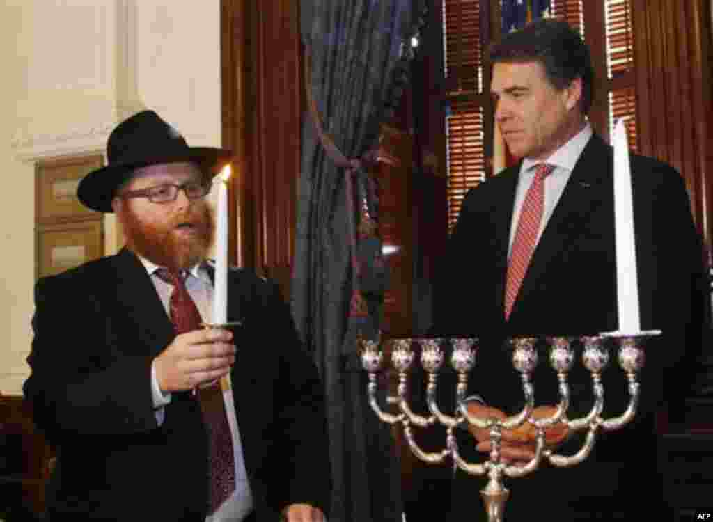 Texas Gov. Rick Perry, right, and Rabbi Yossi Lazaroff take part in a symbolic menorah lighting ceremony on the second day of Hanukkah in Austin, Texas on Thursday, Dec. 2, 2010.(AP Photo/Jack Plunkett)