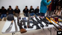 FILE - Suspects in the assassination of Haiti's President Jovenel Moise are shown to the media, along with the weapons and equipment they allegedly used in the attack, in Port-au-Prince, Haiti, July 8, 2021.