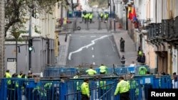 Policías ecuatorianos custodian un retén a poca distancia del Palacio Presidencial en Quito. El Presidente trasladó sus operaciones a la porteña ciudad de Guayaquil.