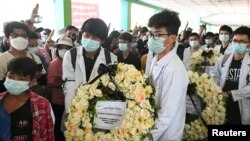 People carry a wreath as they attend the funeral of Khant Nyar Hein, a medical student who was shot and killed during the security force crackdown on anti-coup protesters in Yangon, Myanmar, March 16, 2021.