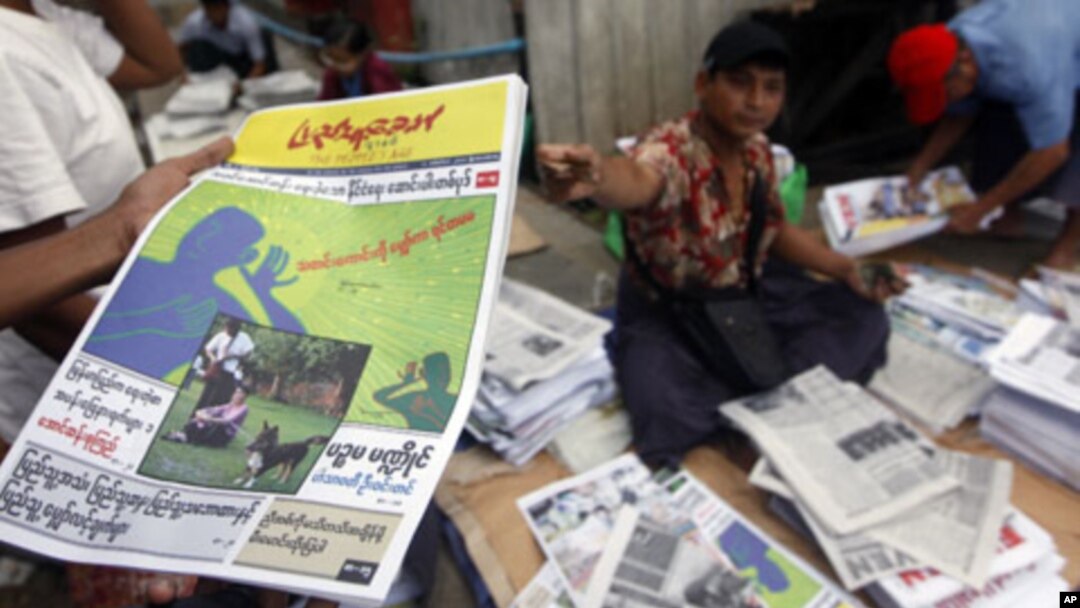 A man shows a People's Age private journal featuring an article written by Burmese pro-democracy leader Aung San Suu Kyi at a market in Rangoon, September 6, 2011. The article, the first written by Suu Kyi that has been allowed to be published in the coun