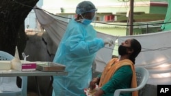 Một nhân viên y tế lấy mẫu thử nghiệm tại một trung tâm thử nghiệm COVID-19 ở Hyderabad, Ấn Độ, ngày 27/10/2020. (AP Photo/Mahesh Kumar A.)