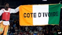 Cheick Cisse of Ivory Coast celebrates with his national flag after winning a men's Taekwondo 80-kg gold medal final at the 2016 Summer Olympics in Rio de Janeiro, Brazil, Aug. 19, 2016.