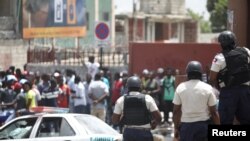 La Police nationale haïtienne surveille une zone commerciale qui a été pillée pendant les manifestations contre les hausses des prix du carburant à Port-au-Prince, Haïti, le 8 juillet 2018. REUTERS / Andres Martinez Casares 