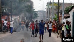 Des habitants entonnent des chants alors qu'ils mettent le feu aux barricades dans un quartier de Kinshasa, en RDC, le 20 décembre 2016.