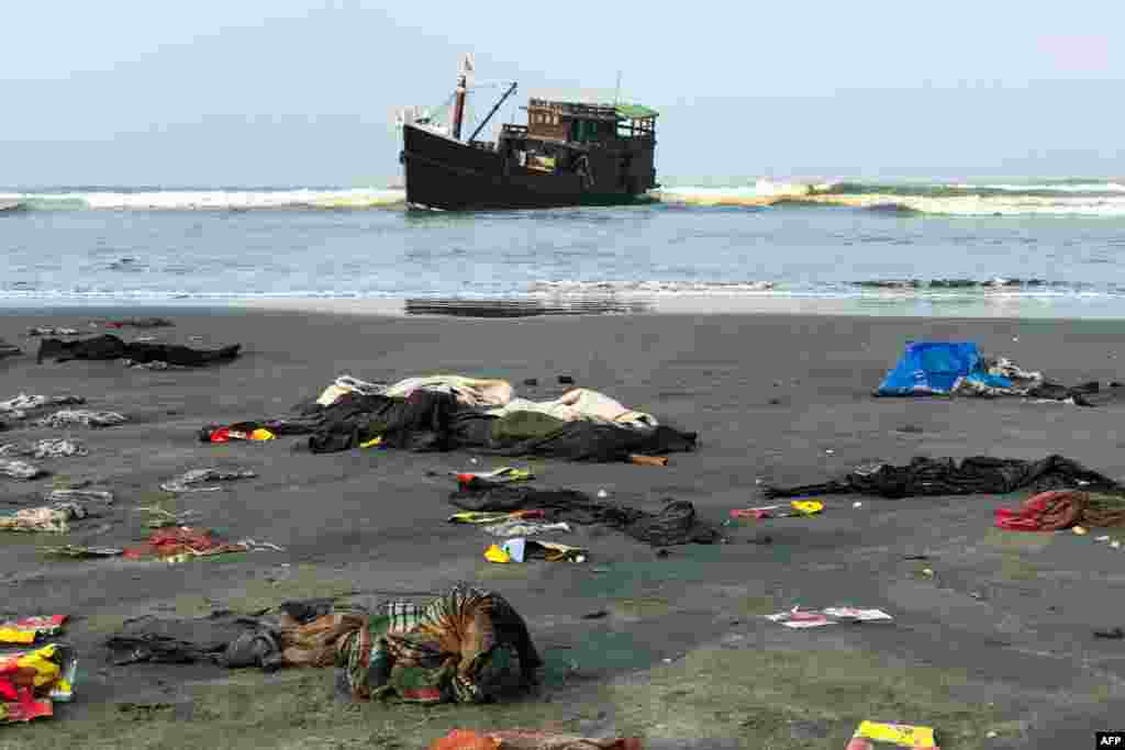 Belongings of Rohingya refugees lay on the shore as their carrier boat remains anchored nearby in Teknaf, Bangladesh. Thirty-two Rohingya died on an overcrowded fishing trawler stranded in the Bay of Bengal for nearly two months, officials said.