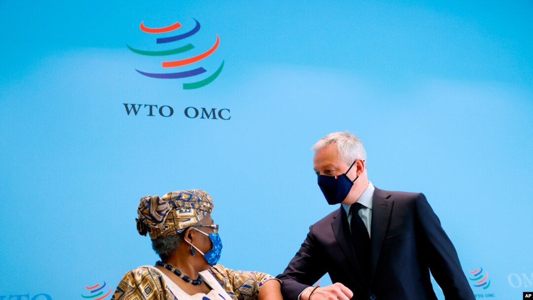 French Finance Minister Bruno Le Maire, right, and World Trade Organisation (WTO) Director-General Ngozi Okonjo-Iweala, left, elbow-bump after a joint news conference at WTO headquarters in Geneva, April 1, 2021.
