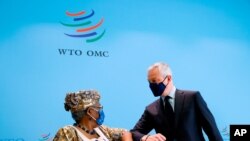 French Finance Minister Bruno Le Maire, right, and World Trade Organisation (WTO) Director-General Ngozi Okonjo-Iweala, left, elbow-bump after a joint news conference at WTO headquarters in Geneva, April 1, 2021.