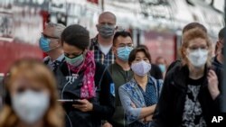 Passengers with face masks arrive in the main train station in Frankfurt, Germany, Aug. 27, 2020. 