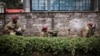 Kenya security forces are seen behind a wall outside the Westgate Mall in Nairobi, Sept. 23, 2013.