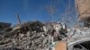 People inspect the wreckage of buildings that were damaged by Saudi-led coalition airstrikes, in Sanaa, Yemen, Tuesday, Jan. 18, 2022.