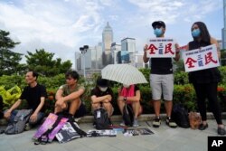 Protesters hold placards reading "Strike for Hong Kong" during continuing pro-democracy rallies in the semi-autonomous Chinese territory, in Tamar Park, Hong Kong, Sept. 3, 2019.