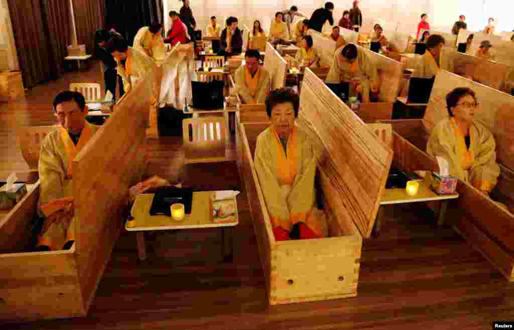 អ្នកចូលរួមក្នុងកម្មវិធី«ពិធីបុណ្យសពអ្នកនៅរស់» អង្គុយក្នុងម្ឈូស ដែលជាផ្នែកមួយនៃកម្មវិធី«ស្លាប់ឲ្យបានល្អ» ក្នុងទីក្រុងសេអ៊ូល ប្រទេសកូរ៉េខាងត្បូងកាលពីថ្ងៃទី៣១ខែវិច្ឆិកា ឆ្នាំ២០១៩។