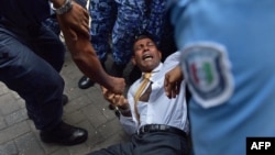 ຕຳຫລວດ ມາລດິບ ພະຍານຍາມແກ່ດືງ ອະດີດປະທານາທິບໍດີມາລດິບ ທ່ານ Mohammed Nasheed ເຂົ້າໄປໃນສານ.