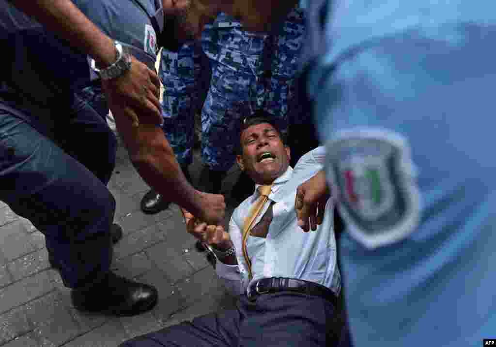 Maldives police try to move former President Mohamed Nasheed during a scuffle as he arrives at a courthouse in Male. Nasheed was denied bail a day after his surprise arrest on terrorism charges.