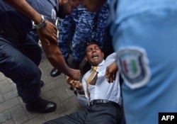 Maldives police try to move former president Mohamed Nasheed during a scuffle as he arrives at a courthouse in Male, Feb. 23, 2015.