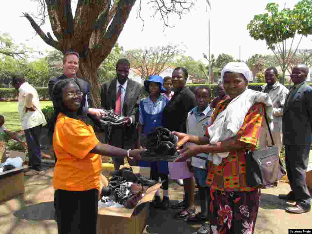 Parents of children at a Zimbabwean school receiving new shoes from Shoes for Healing Campaign.