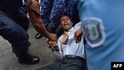 Maldives police try to move former president Mohamed Nasheed during a scuffle as he arrives at a courthouse in Male, Feb. 23, 2015. 