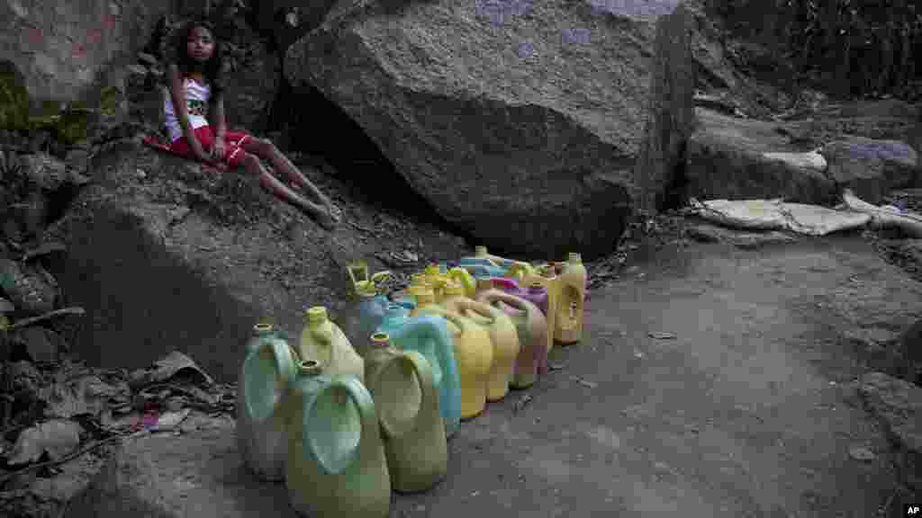 Une petite fille attend l&#39;arrivée de l&#39;approvisionnement de eau à un robinet public à Gauhati, Inde, le 21 mars 2017.