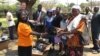 Parents of children at a Zimbabwean school receiving new shoes from Shoes for Healing Campaign.