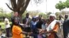 Parents of children at a Zimbabwean school receiving new shoes from Shoes for Healing Campaign.