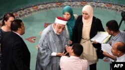 Abdelfattah Mouro, center, deputy president of the Tunisian Assembly, speaks with deputies during debate on anti-terror legislation in Tunis, July 24, 2015.