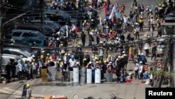 Demonstrators block a road during an anti-coup protest in Yangon, Myanmar, March 4, 2021.