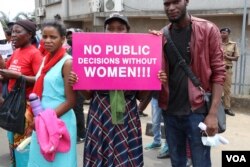 A protestor carries a sign during Friday's women rights demonstration in Malawi. (Lameck Masina/VOA)