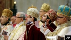 Para uskup mengambil foto ketika Paus Fransiskus memperingati 100 tahun pembunuhan massal di Armenia, di Basilika Santo Petrus, Vatikan, Minggu 12 April 2015.