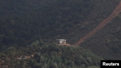 2021년 10월 5일 한국 김포의 남북 비무장지대(DMZ) 남측 애기봉 평화생태공원 전망대에서 바라본 북한군 초소에서 북한군 병사들이 경계 근무를 서고 있다.