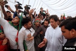FILE - Imran Khan (2nd R), chairman of the Pakistan Tehreek-e-Insaf (PTI) political party, gestures as he walks among supporters during a campaign rally ahead of general elections in Karachi, Pakistan, July 4, 2018.
