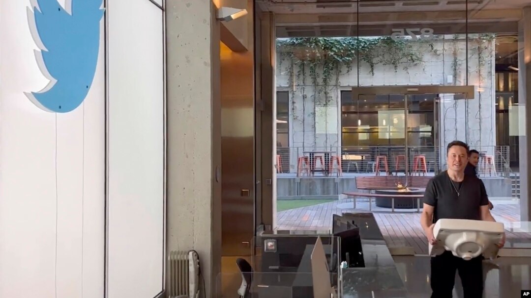 This image from the Twitter page of Elon Musk shows Musk entering Twitter headquarters carrying a sink through the lobby area, Oct. 26, 2022 in San Francisco. 