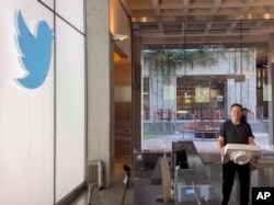 This image from the Twitter page of Elon Musk shows Musk entering Twitter headquarters carrying a sink through the lobby area on Wednesday, Oct. 26, 2022 in San Francisco. Musk posted a video Wednesday showing him strolling into Twitter headquarters ahead of a Friday deadline to close his $44 billion deal to buy the company. (Twitter page of Elon Musk via AP)