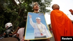 FILE - Supporters of opposition leader Kem Sokha, hold up a poster near the Appeal Court in Phnom Penh, Cambodia, March 27, 2018.