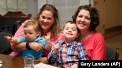 Pam Yorksmith, left, and her spouse Nicole Yorksmith, pose with their children, Grayden, 4, and Orion, in this April 2015 photo. (AP Photo/Gary Landers)