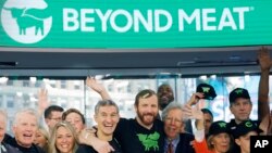 Ethan Brown, center, CEO of Beyond Meat, attends the Opening Bell ceremony with guests to celebrate the company's IPO at Nasdaq, Thursday, May 2, 2019 in New York. California-based Beyond Meat makes burgers and sausages out of pea protein and other ingredients.