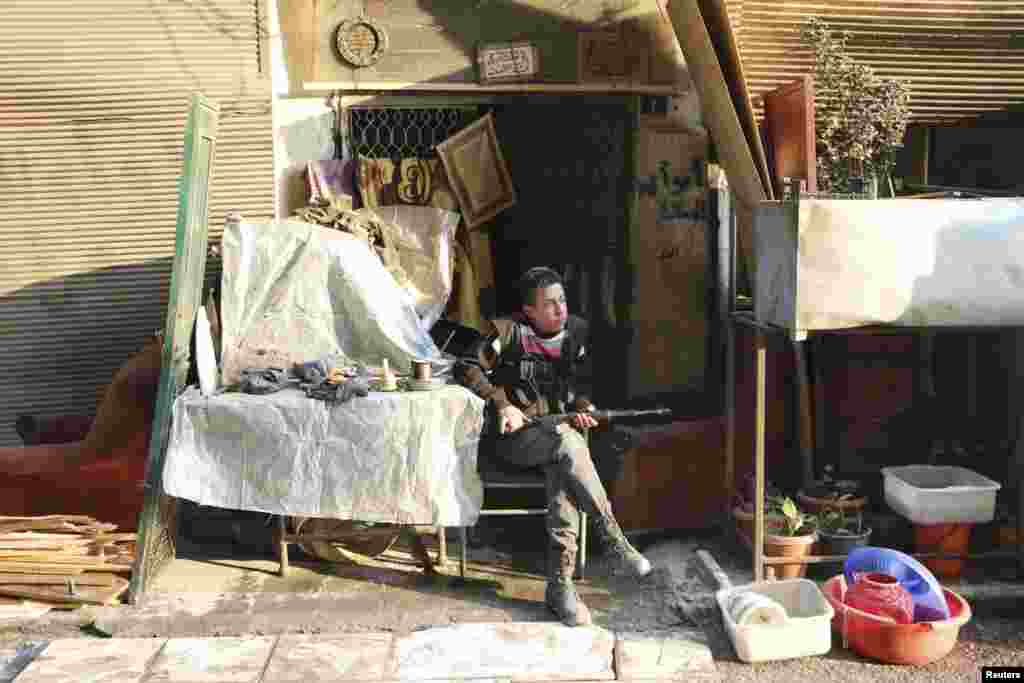 A Free Syrian Army fighter rests with his weapon in the Sheikh Maqsoud neighborhood of Aleppo, Feb. 16, 2014.&nbsp;