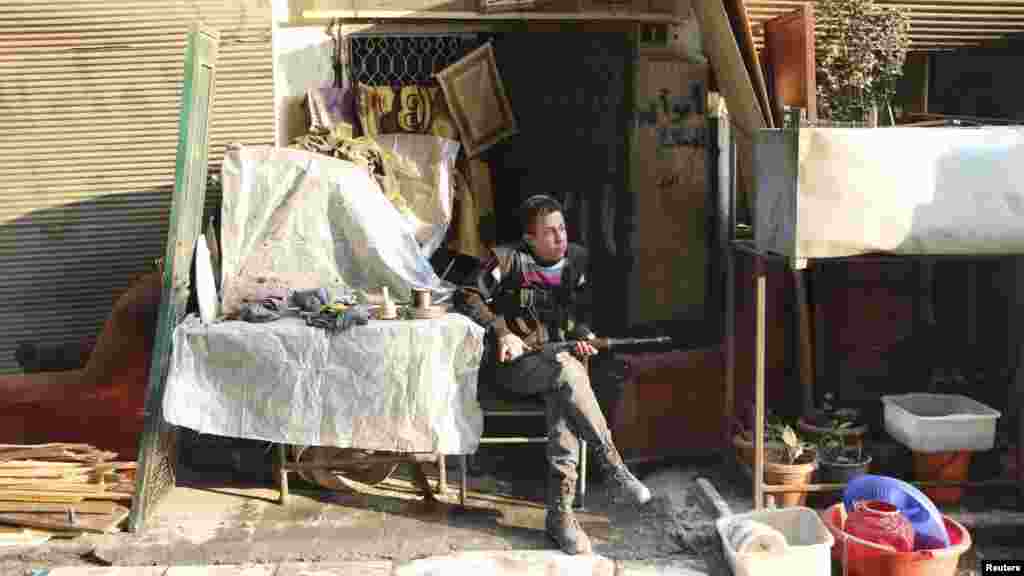 A Free Syrian Army fighter rests with his weapon in the Sheikh Maqsoud neighborhood of Aleppo, Feb. 16, 2014.&nbsp;